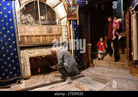 Bethléem, Cisjordanie. 17 décembre 2023. Les chrétiens palestiniens visitent la grotte de l’église de la Nativité, qui serait le lieu de naissance de Jésus, dans la ville biblique de Bethléem, Cisjordanie, le dimanche 17 décembre 2023. L’église, normalement remplie de touristes, est vide depuis octobre 8, le lendemain de l’attaque du Hamas contre Israël et du début de la guerre dans la bande de Gaza. Les dirigeants chrétiens ont annulé l’érection du sapin de Noël sur la place du Manager, les joyeuses décorations de rue et les célébrations en solidarité avec les Palestiniens de Gaza. Photo de Debbie Hill/ crédit : UPI/Alamy Live News Banque D'Images