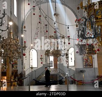 Bethléem, Cisjordanie. 17 décembre 2023. Un moine marche dans l’église vide de la Nativité, qui serait le site de la naissance de Jésus, dans la ville biblique de Bethléem, Cisjordanie, le dimanche 17 décembre 2023. L’église, normalement remplie de touristes, est vide depuis octobre 8, le lendemain de l’attaque du Hamas contre Israël et du début de la guerre dans la bande de Gaza. Les dirigeants chrétiens ont annulé l’érection du sapin de Noël sur la place du Manager, les joyeuses décorations de rue et les célébrations en solidarité avec les Palestiniens de Gaza. Photo de Debbie Hill/ crédit : UPI/Alamy Live News Banque D'Images