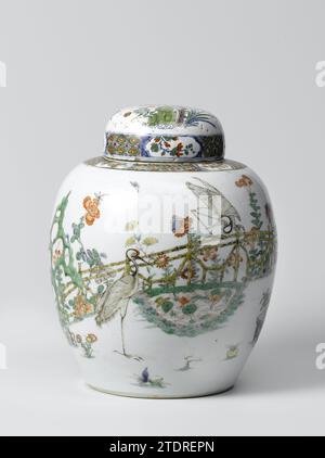 Pot à couvercle, anonyme, c. 1700 - c. 1720 couvercle en forme d'oeuf pot en porcelaine, peint sur le glaçage en bleu, rouge, vert, jaune, aubergine et noir. Sur le mur un jardin clôturé avec deux grues, une debout et une sur la clôture, près d'un étang avec des plantes de lotus, un rocher et un arbre à fleurs (Magnolia). Autour de l'étang des plantes à fleurs (chrysanthème, splendide, pivoine, aster, lys) et deux pots de fleurs avec du pin, du bambou et de l'orange. Dans le magnolia un perroquet sur un rack. En outre, deux oiseaux volants. Sur l'épaule servetwork entrecoupé de branches de fleurs dans des cartouches. Le couvercle a ensuite été fabriqué en t Banque D'Images