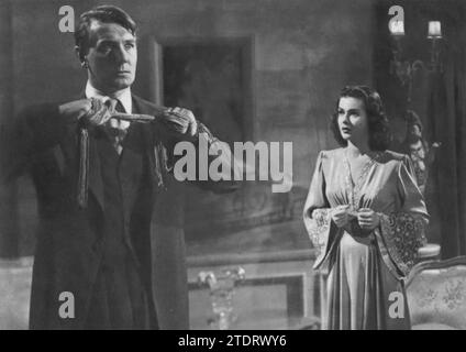 Michael Redgrave et Joan Bennett jouent dans le thriller psychologique Secret Beyond the Door (1947). Réalisé par Fritz Lang, ce film explore les aspects sombres de la psyché humaine. Redgrave joue un homme avec un passé mystérieux, et Bennett dépeint sa nouvelle épouse qui devient de plus en plus préoccupée par le comportement étrange de son mari et les secrets cachés dans leur maison. Le film est connu pour son atmosphère de suspense et l'exploration de thèmes tels que l'obsession et la paranoïa, avec Redgrave et Bennett livrant des performances intenses et captivantes. Banque D'Images