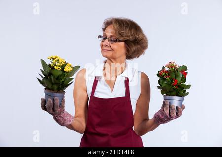 Belle femme senior prendre soin de ses fleurs Banque D'Images