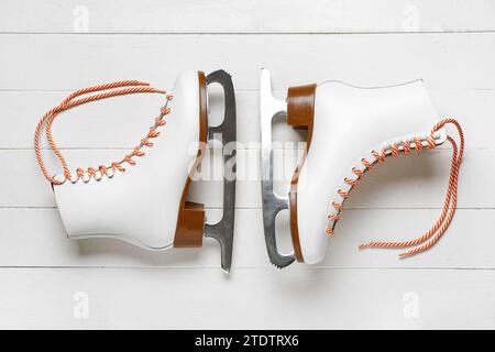 Patins à glace sur fond en bois blanc Banque D'Images
