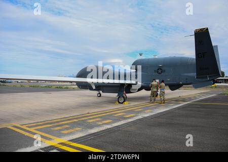 Un RQ-4 Global Hawk Block 40 est stationné sur la piste le 1 novembre 2023, à la base aérienne navale de Sigonella, en Italie. Les spécialistes de l'avionique du 7e escadron de reconnaissance effectuent des vérifications de routine une fois qu'un RQ-4 atterrit sur la ligne de vol pour vérifier ou tout dommage subi en vol avant que l'avion ne se lance pour une autre mission. (Photo de l'US Air Force par l'aviateur de 1e classe Colin Perkins) Banque D'Images