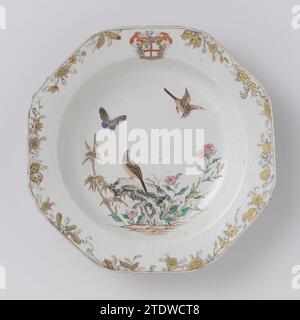 Assiette à soupe octogonale avec les bras de la famille Darcet et deux oiseaux et plantes à fleurs près d'un rocher, anonyme, c. 1740 - c. 1760 assiette à soupe octogonale en porcelaine avec coins serrés, peinte sur le glaçage en bleu, rouge, rose, vert, brun, noir et or. Sur le plat un oiseau sur un rocher avec des plantes à fleurs et du bambou, un deuxième oiseau et un papillon dans les airs ; sur le bord la crête familiale de Darcet avec une croix rouge et un dragon ; sur le bord des branches de fleurs et de fruits à encre de Chine. Quelques copeaux dans le bord. Porcelaine d'arme avec des couleurs d'email. Porcelaine de Chine. glaçage. peinture or (métal) / Banque D'Images