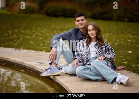 Jeune couple s'embrassant et se réjouissant au lac. charmant jeune couple s'embrassant dehors en automne. Couple amoureux marchant dans la nature. Ambiance automnale. Homme heureux Banque D'Images