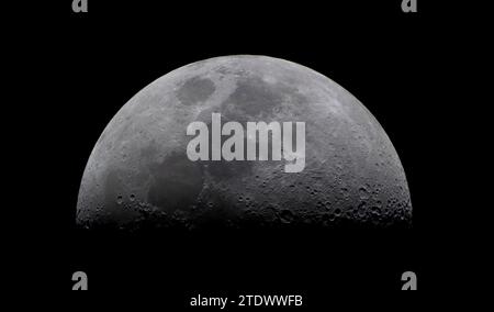 Londres, Royaume-Uni. 19 décembre 2023. Une demi-lune illuminée (le premier quart de lune) dans un ciel clair et immobile au-dessus de Londres, des cratères clairement visibles sur cette image du télescope couleur. Crédit : Malcolm Park Banque D'Images