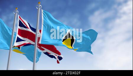Drapeaux nationaux de Sainte-Lucie brandissant avec le drapeau du Royaume-Uni par temps clair. État insulaire du Commonwealth en Amérique centrale. rendu d'illustration 3d. Banque D'Images