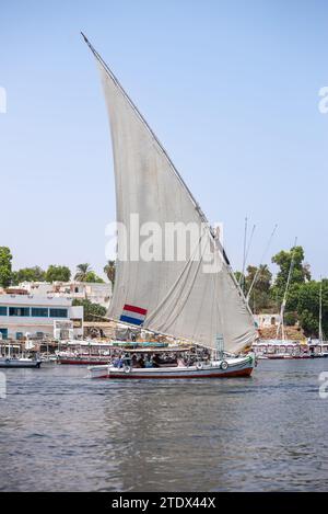 Un bateau à voile traditionnel 'Felucca' sur le Nil transportant des touristes près d'Assouan, Egypte Banque D'Images