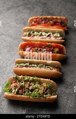 Délicieux hot-dogs avec différentes garnitures sur la table grise Banque D'Images