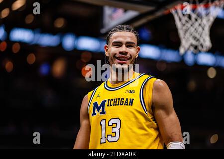 Charlotte, Caroline du Nord, États-Unis. 19 décembre 2023. L’attaquant des Michigan Wolverines Olivier Nkamhoua (13) sourit en première mi-temps contre les Gators de Floride lors de l’invitation Jumpman 2023 au Spectrum Center à Charlotte, en Caroline du Nord. (Scott Kinser/CSM). Crédit : csm/Alamy Live News Banque D'Images