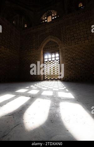 27 JUIN 2023, BOUKHARA, OUZBÉKISTAN : Mausolée Ismail Samani ou intérieur du mausolée Samanide avec l'ombre de la fenêtre au coucher du soleil, 9e -10e cen Banque D'Images