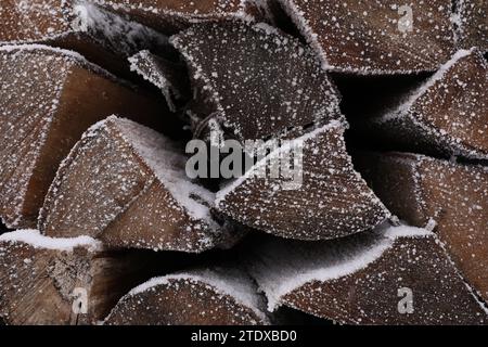 Bois de chauffage empilé avec de la neige et de l'hoarfrost comme fond, gros plan Banque D'Images