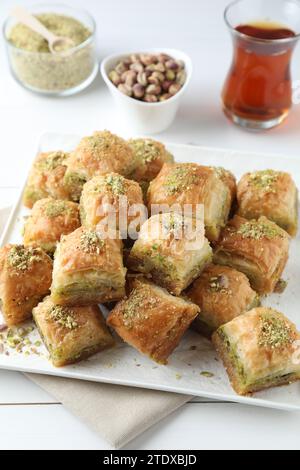 Délicieux baklava frais avec des noix hachées servi sur une table blanche. Bonbons orientaux Banque D'Images