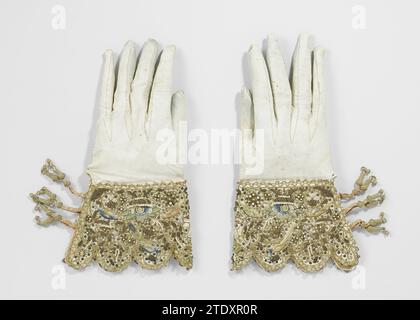 Une paire de gants de mariage, anonyme, gant de mariée gauche 1622 en cuir de cire blanc, capuche richement brodée. Capuchon à bord lobé. Fermé par trois paires de bandes de dentelle rose, sur lesquelles un bouton doré est poussé. Motif symétrique de, entre autres choses, deux mains dans le contour brun sous l'une avec des flèches percé le cœur de gemmes et deux oiseaux tordus. Motif riche en différentes couleurs, broderie, perles et paillettes. Autour de la passification d'or de Kloskant. Pays-Bas entier : chamois (matériel animal). Pneus : soie. Décoration:. Décoration : dentelle de canette / broderie gauche gant de mariée fou Banque D'Images