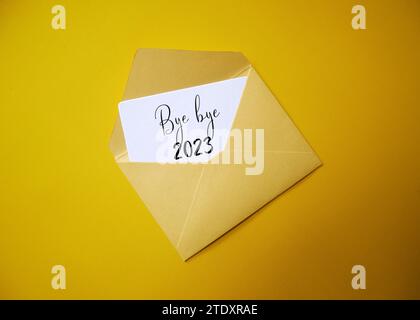 Carte de remerciement 2023 dans une enveloppe blanche avec fond de couleur. bye-bye 2023, et bienvenue 2024. Banque D'Images