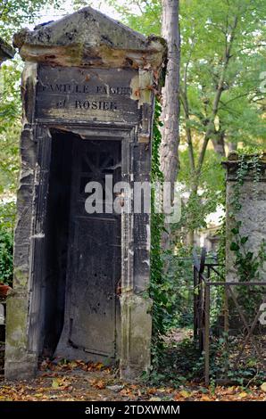 Un mausolée patiné se dresse dans le cimetière historique du Père Lachaise de Paris. Banque D'Images