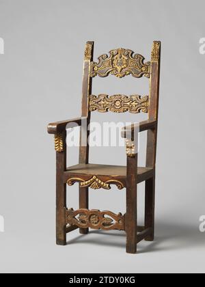 Armstoel, anonyme, 1500 - 1600 fauteuil de nuthout, partiellement doré. Les jambes avant se terminent comme des jambes, qui sont décorées au sommet avec des consoles à feuilles, et qui soutiennent les accoudoirs, se terminant par des volutes. La présence sciée, la préfigure et les sports du dos sont décorés, entre autres, de motifs de feuilles poignardées, de rosettes et de volutes. Les backstyles, couronnés de motifs de feuilles, Hellen à l'envers. Le sport supérieur du dos porte un blason avec des fleurs, des balles et une étoile. Les jambes sont carrées. Voir aussi BK-16646-A, B et C. Italie bois (matériel végétal). noyer (bois dur). dorure (matériel) gil Banque D'Images