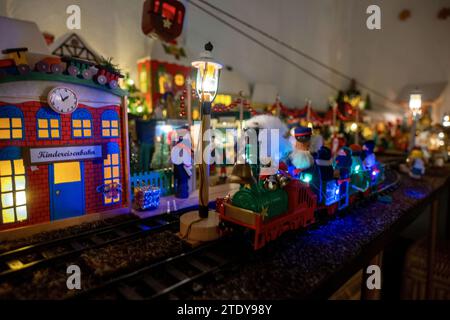 Coburg, Allemagne. 05 décembre 2023. Un train miniature passe devant les étals d'un marché de Noël miniature. À environ 20 mètres à vol d'oiseau de la place du marché de Coburg, Horst Gründel, travailleur social qualifié et maintenant retraité, a créé un paysage hivernal unique et détaillé. Un marché de Noël miniature mesurant environ huit mètres carrés est installé dans une pièce de son appartement. Plus de 30 stands, un chemin de fer modèle, quatre scènes de nativité, une gondole, un carrousel et bien plus encore animent le paysage. Gründel a commencé à fabriquer les premiers stands dans les années 1970 Crédit : Pia Bayer/dpa/Alamy Live News Banque D'Images