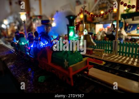 Coburg, Allemagne. 05 décembre 2023. Un train miniature passe devant les étals d'un marché de Noël miniature. À environ 20 mètres à vol d'oiseau de la place du marché de Coburg, Horst Gründel, travailleur social qualifié et maintenant retraité, a créé un paysage hivernal unique et détaillé. Un marché de Noël miniature mesurant environ huit mètres carrés est installé dans une pièce de son appartement. Plus de 30 stands, un chemin de fer modèle, quatre scènes de nativité, une gondole, un carrousel et bien plus encore animent le paysage. Gründel a commencé à fabriquer les premiers stands dans les années 1970 Crédit : Pia Bayer/dpa/Alamy Live News Banque D'Images