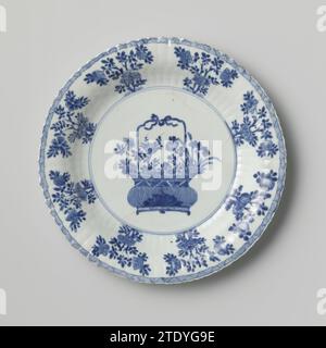 Plat avec côtés cannelés, panier de fleurs et sprays de fleurs, anonyme, c. 1700 - c. 1724 soucoupe en porcelaine avec paroi nervurée et bord lobé, peinte en bleu sous-couche. Sur le plat un panier de fleurs avec chrysanthème, pivoine, prunus et lotus et deux feuilles d'artémisia ; le mur avec des branches de fleurs ; sur le bord un lien avec ombrage ; trois branches de fleurs sur le dos. Marqué sur le dessous avec une feuille d'artémisia dans un double cercle. Fissures dans le sol. Bleu blanc. Porcelaine de Chine. glaçage. Cobalt (minéral) peinture / vitrification soucoupe en porcelaine avec paroi nervurée et bord lobé, peint en sous-laze bl Banque D'Images