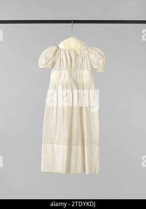 Robe pour enfants en lin blanc avec une manche bouffante courte, un corps court avec des plis fins, une large ceinture lisse et une jupe finement plissée, décorée de broderies anglaises, anonyme, c. 1800 - c. 1835 Robe pour enfants en lin blanc au-dessus de l'ourlet, décoré avec un bord de broderie anglaise. Haut taile avec ceinture large. Collier carré et manches bouffantes. Jupe par derrière avec plis profonds sur la ceinture ridée. Fermeture au milieu. Les boucles blanches sous et le long des trous de bras sont frappantes. Lin néerlandais (matériel) broderie Robe pour enfants en lin blanc Banque D'Images