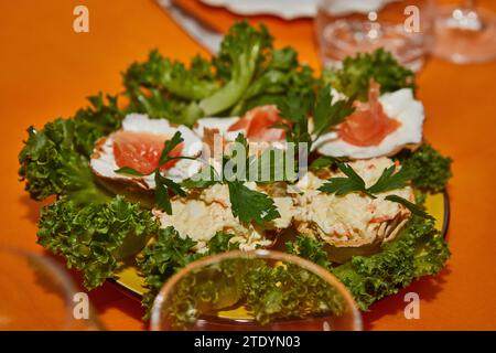 Table de fête du nouvel an magnifiquement arrangée avec paniers de fromage, saumon frais et verts vibrants, créant une atmosphère élégante et accueillante Banque D'Images