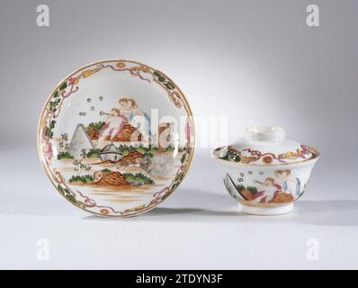 Soucoupe avec une image symbolique de trois putti et différents objets, anonyme, c. 1750 - c. 1760 plat en porcelaine, peint sur la glaçure en bleu, rouge, rose, vert, jaune, marron, noir et or. Sur le plat du plat une représentation symbolique avec trois putti, une bulle de savon souffle à travers un tuyau ; pour eux un panier en osier, pyramide, crâne, masque, couronne, globe, livres et autres objets ; le bord avec une feuille de pneu vignes et deux soleils radieux avec un visage. Présentation d'un dessin de Jacob de Wit (1695-1754), 'allégorie de l'éphémère'. Deux fissures dans la paroi du plat. Performance européenne dans email co Banque D'Images