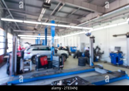 Image floue à l'intérieur du centre d'entretien des pneus. Remplacement du caoutchouc sur les roues de voiture. Équilibrage des roues. Atelier de réparation automobile de centre de service de pneu de voiture brouillé backgr Banque D'Images