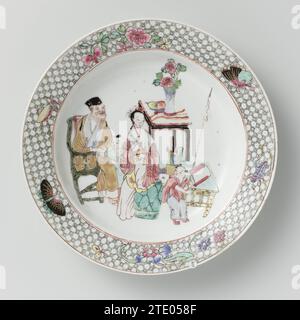 Assiette à soupe avec un vieil homme, une femme et deux garçons parmi des objets précieux, anonyme, c. 1800 - c. 1899 assiette à soupe en porcelaine, peinte sur le glaçage en bleu, rouge, rose, vert, jaune, noir et or. Sur l'appartement une femme assise, un vieil homme et deux garçons parmi des symboles de bonheur tels qu'un vase à fleurs, un bol de fruits avec fingercitroen, rouleaux etc. ; Sur le bord deux branches de fleurs, deux papillons et deux sauterelles sur un fond de service. L'arête a été cassée. Ancienne étiquette sur le fond avec 'Collection T./ 170'. Famle Rose. Porcelaine de Chine. glaçage. peinture or (métal) / dorure / vitrificati Banque D'Images