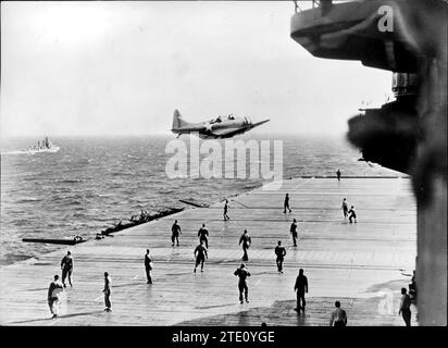 12/31/1941. Les équipages sur le poste d'envol d'un porte-avions nord-américain attendent de récupérer un message lancé par un avion de reconnaissance à son retour d'un vol de reconnaissance. La mitrailleuse arrière relâche la note pendant que le pilote vole bas. Crédit : Album / Archivo ABC Banque D'Images