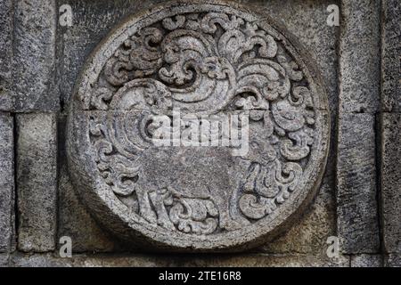 médaillon dans le temple de penataran avec des reliefs d'animaux. Banque D'Images