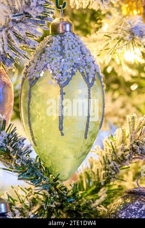 Une décoration/boule de Noël verte translucide, suspendue à un arbre de Noël Banque D'Images