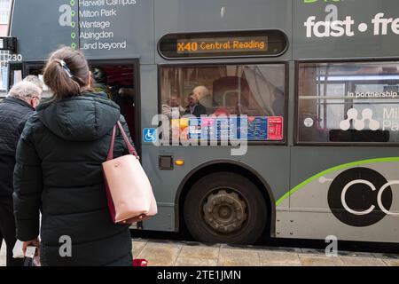 les gens entrent dans un bus. Les personnes à proximité sont reflétées dans la fenêtre Banque D'Images