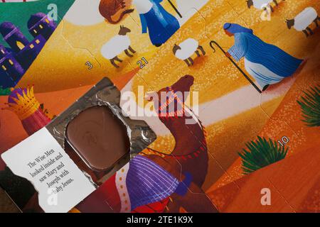 Porte ouverte sur le calendrier de l'Avent de la nativité montrant le chocolat et une partie de l'histoire de la nativité Banque D'Images