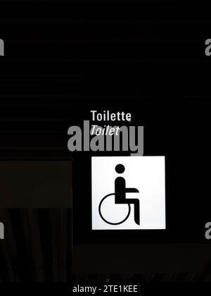 Francfort, Allemagne - 7 juin 2023 - Affichage noir avec un pictogramme pour une personne handicapée en fauteuil roulant et le texte 'toilette' et 'toilette' Banque D'Images