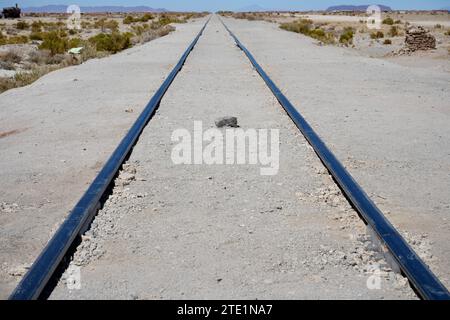 Lignes de chemin de fer se dirigeant au loin dans le désert, Bolivie. Banque D'Images