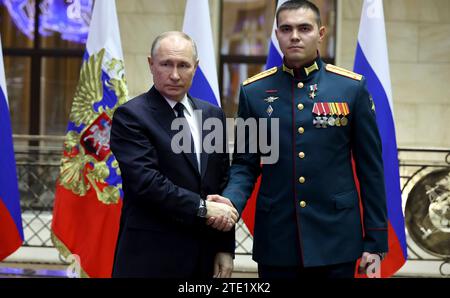 Moscou, Russie. 19 décembre 2023. Le président russe Vladimir Poutine, à gauche, serre la main du capitaine Ainur Safiullin après avoir remis la médaille d’or au Centre de contrôle de la Défense nationale, le 19 décembre 2023 à Moscou, en Russie. Crédit : Mikhail Klimentyev/Kremlin Pool/Alamy Live News Banque D'Images