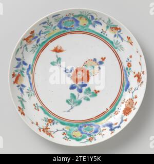 Soucoupe-plat avec plante à fleurs, anonyme, c. 1675 - c. 1685 plat en porcelaine, peint sur le glaçage en bleu, rouge, vert, jaune, noir et or. Une branche de chrysanthème sur l'appartement. Le mur intérieur avec deux rochers avec des plantes à fleurs (grenade, prunus). Ancienne étiquette sur le fond avec 'Collection Westendorp/ 51'. Quatre pronen sur le fond. Style Kakiemon. Porcelaine du Japon. glaçage. Or (métal) dorure / vitrification plat en porcelaine, peint sur le glaçage en bleu, rouge, vert, jaune, noir et or. Une branche de chrysanthème sur l'appartement. Le mur intérieur avec deux rochers avec des plantes à fleurs (pomegra Banque D'Images