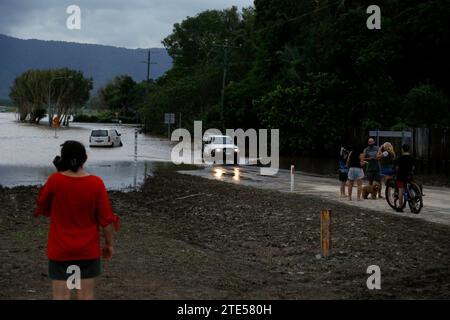 Cairns, Australie. 18 décembre 2023. Les habitants de Holloways Beach regardent une voiture traverser les eaux de crue sur la route principale entrant et sortant de la banlieue inondée. Les inondations majeures de la rivière Barron et la marée haute avec plus de 1000 mm de pluie ont coupé la zone. Crédit : SOPA Images Limited/Alamy Live News Banque D'Images