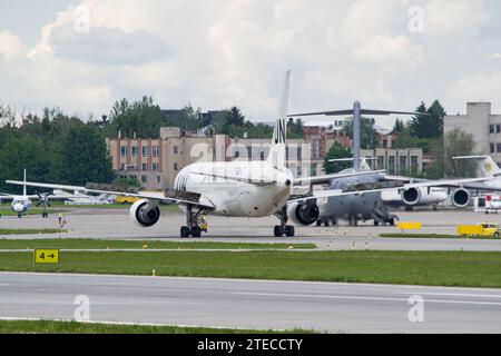 Boeing 767-300 des Nations Unies au sol après avoir atterri à Lviv, avec le Boeing C-17 Globemaster III de l'US Air Force en arrière-plan Banque D'Images