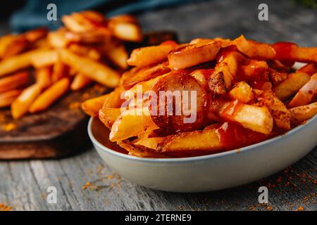 gros plan de quelques currywursts tranchés garnis du ketchup au curry typique et de la poudre de curry servie avec des chips, comme c'est le cas en allemagne Banque D'Images