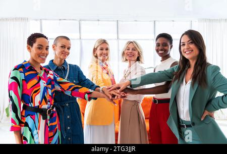 Groupe de belles femmes d'affaires confiantes se réunissant dans le bureau - Multiethinc équipe créative féminine brainstorming au travail - collègues divers travaillant Banque D'Images