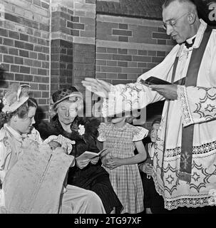 Clerc baptise bébé ca. Mai 1950 Banque D'Images