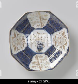 Plat octogonal avec des plantes à fleurs dans des panneaux et des sprays de fleurs, anonyme, c. 1700 - c. 1799 plat octogonal avec couvercle bol de porcelaine, peint en bleu glacé sous-jacent et sur l'or glacé. L'avant de la soucoupe est recouvert d'un bleu glacé sous-jacent avec des branches de fleurs en or. Dans elle a sauvé un médaillon octogonal avec un vase de fleur avec autour sur le bord, quatre cartouches festonnées avec des plantes à fleurs (Prunus, Bamboo) et une pivoine stylisée. Le mur extérieur avec trois branches de prunus. Deux prenes sur le fond. Imari. Porcelaine du Japon. glaçage. cobalt (minéral). peinture or (métal) / dorure / vi Banque D'Images