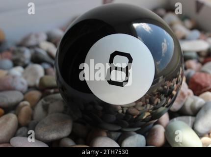 Photo en gros plan de Black Billiard ball avec le numéro huit dans White Circle on A Rocks Banque D'Images