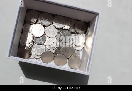 Pièces ukrainiennes dénomination 1 et 2 hryvnia dans une boîte en carton studio isolé photo stock Banque D'Images