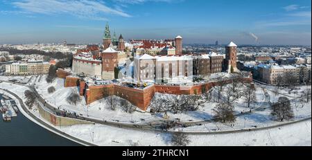 Cracovie, Pologne. Cathédrale royale du Wawel et château couvert de neige en hiver. Rivière Vistule et bateaux touristiques. Panorama aérien avec boulevard, promena Banque D'Images