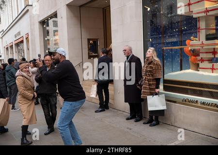 Touristes festifs en force prenant des selfies et des photos d'expositions de Noël le long de Old Bond Street au cœur de Mayfair à Londres, le 20 décembre 2023. Banque D'Images