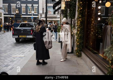 Touristes festifs en force prenant des selfies et des photos d'expositions de Noël le long de Old Bond Street au cœur de Mayfair à Londres, le 20 décembre 2023. Banque D'Images