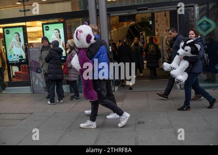 Touristes festifs en force prenant des selfies et des photos de Noël à Mayfair de Londres, le 20 décembre 2023. Banque D'Images